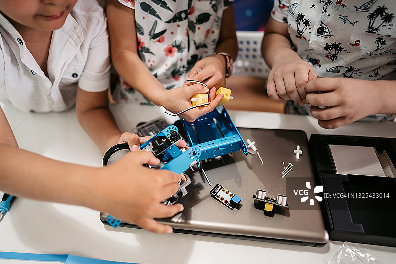 计算机编码课上的学生正在构建和编程机器人车辆图片素材
