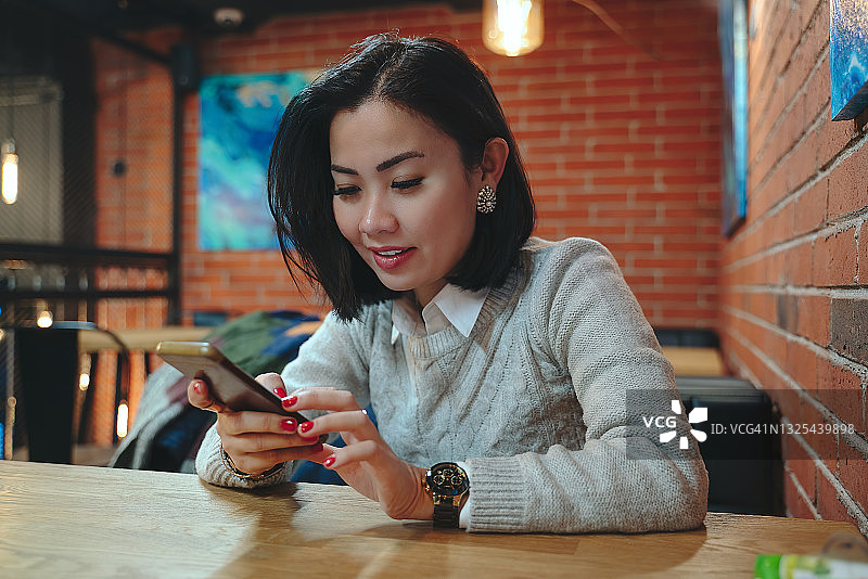 在咖啡店使用手机的女人图片素材