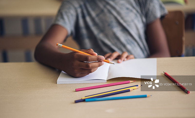 男孩在笔记本上写字图片素材