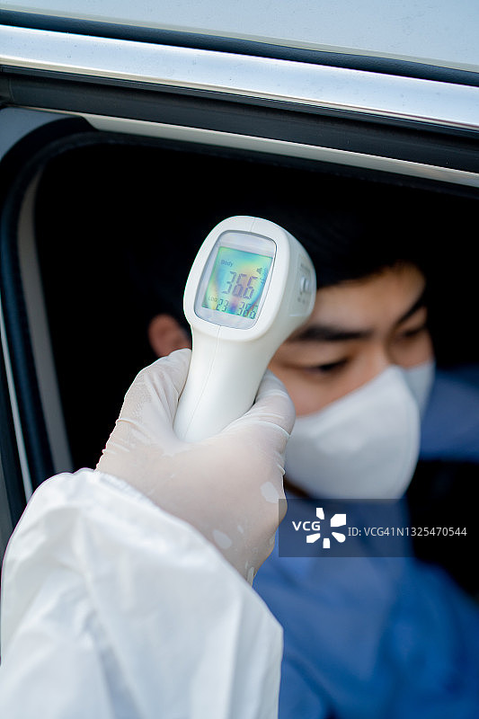 开车去做鼻拭子检测冠状病毒感染的年轻男人图片素材