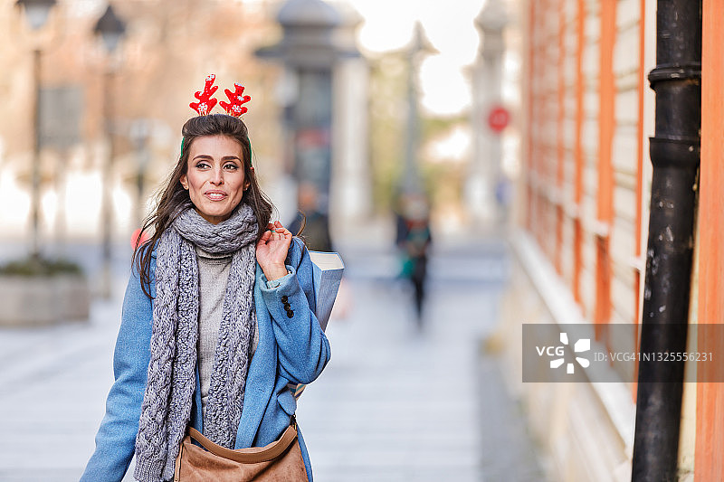 假日购物：手提纸袋站在城市街区的女人图片素材