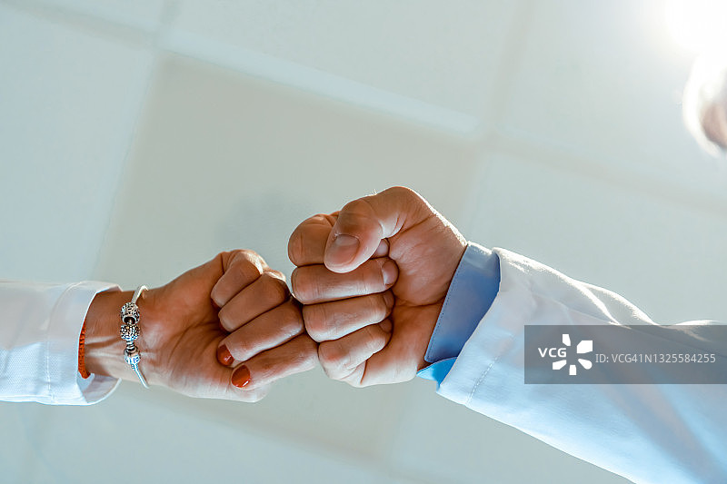 决心成就一切：疫情期间医生的握拳致意图片素材