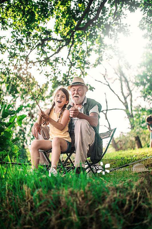 祖父母和孙女在湖上一起钓鱼图片素材