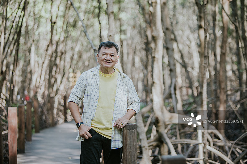 父亲站在红树林前微笑拍照图片素材