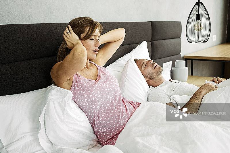 女人因丈夫打鼾无法入睡躺在床上图片素材