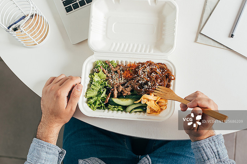 在手中享用健康的午餐：均衡饮食概念图片素材