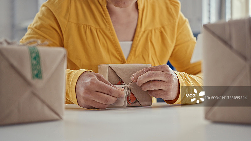 生态理念：用回收材料包装礼品的手图片素材