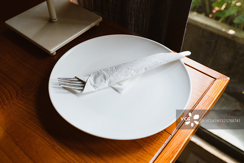 桌子上放着一个空盘子和一套新的餐具图片素材