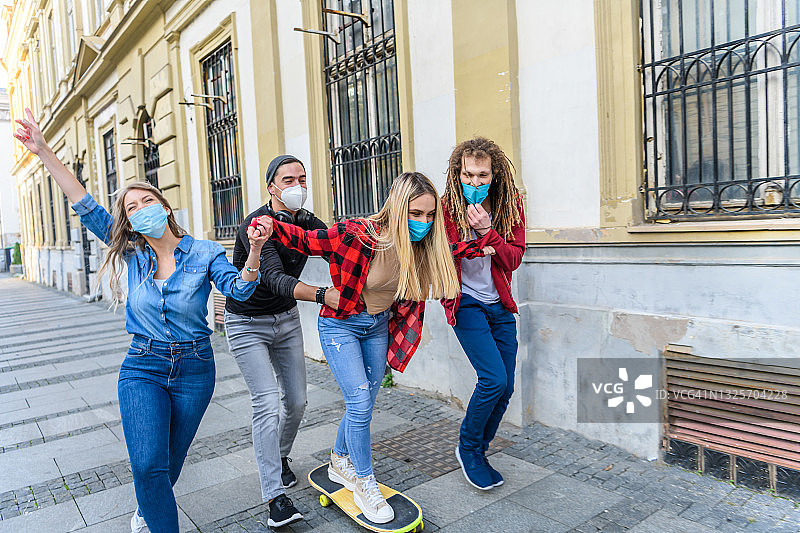 一群年轻学生在城市街道上玩滑板图片素材