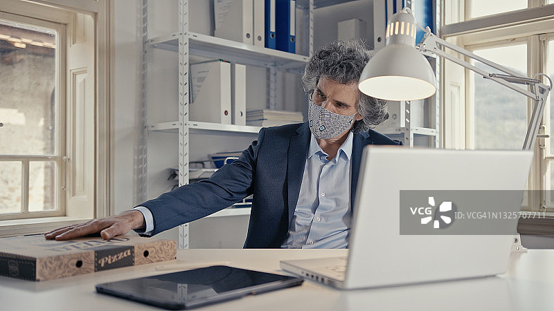 疫情期间在办公室收到披萨外卖的商人，新常态图片素材