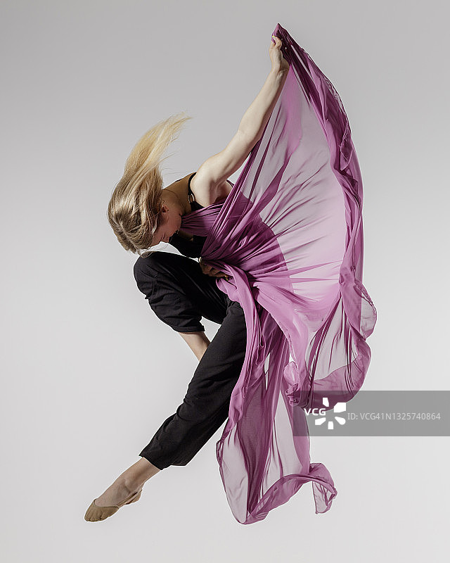 灰色背景上的舞者与空中纺织品图片素材