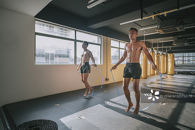 健身房里跳绳的亚洲男运动员图片素材