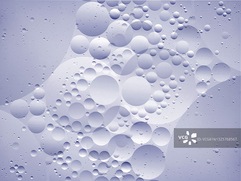 白色液体背景上的气泡和液滴形成的抽象形状和纹理特写镜头图片素材