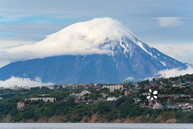 从海上眺望堪察加彼得罗巴甫洛夫斯克市的秋景，居民楼位于太平洋沿岸山丘上，科里亚克火山锥图片素材