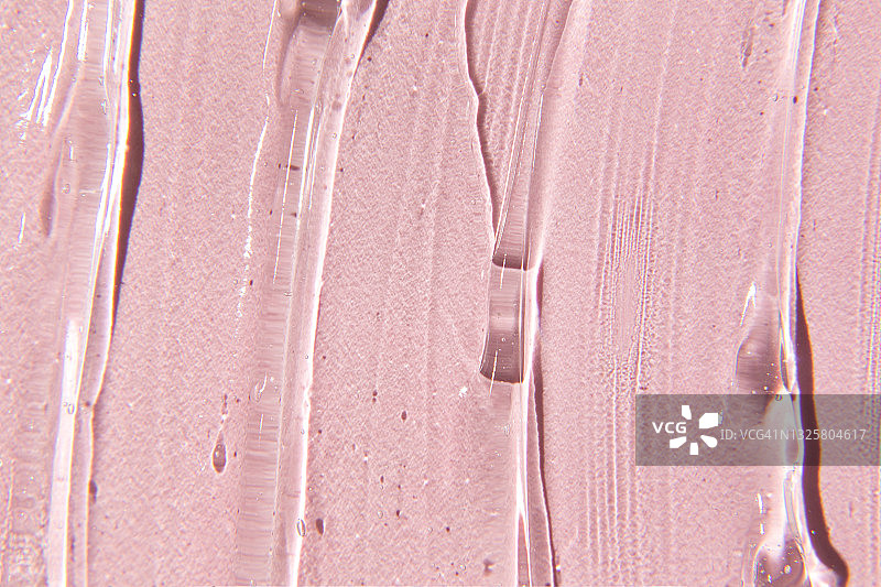 凝胶霜的质地。粉色背景上的透明质酸凝胶图片素材