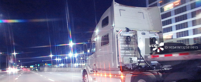 夜晚高速公路上的电动半挂卡车图片素材