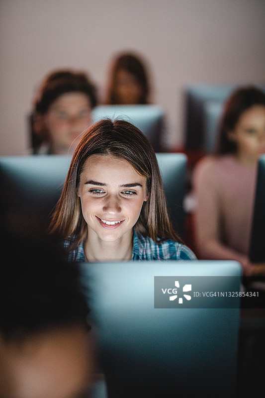 在电脑室上课的快乐女学生图片素材