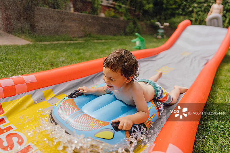 在水滑梯上玩耍的小男孩图片素材