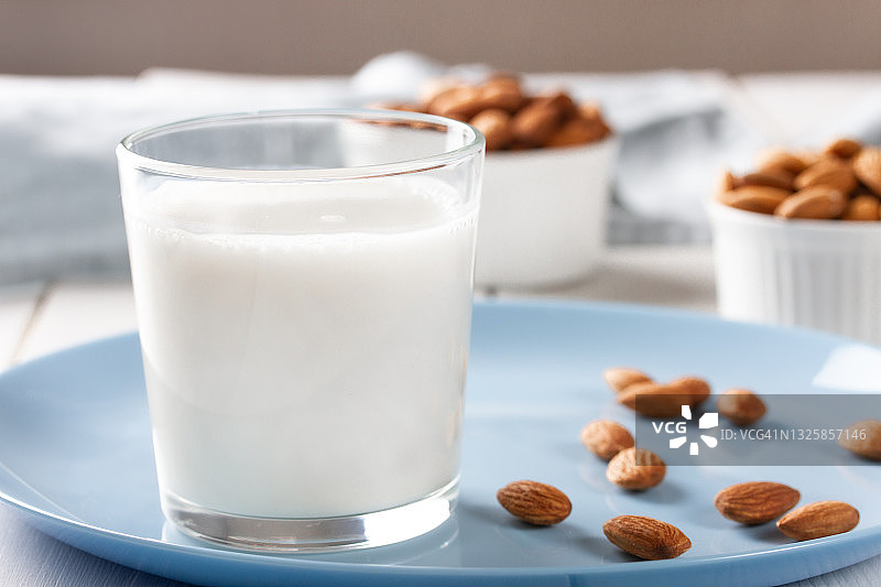 白色木质背景上的一杯杏仁奶图片素材