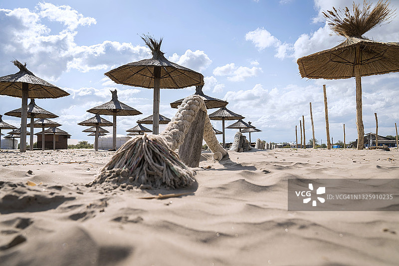 海滩上带茅草伞的躺椅，高角度图片素材