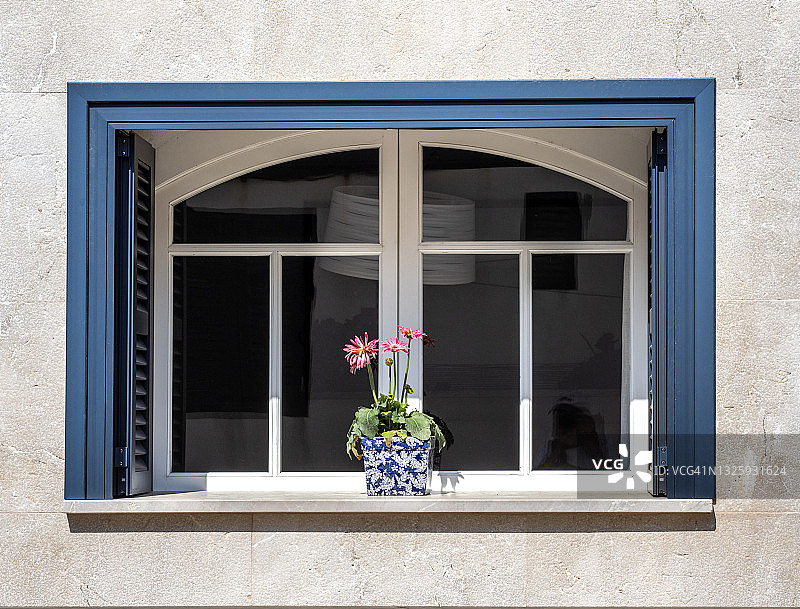 带木窗和雏菊花台面的白色房屋外墙图片素材