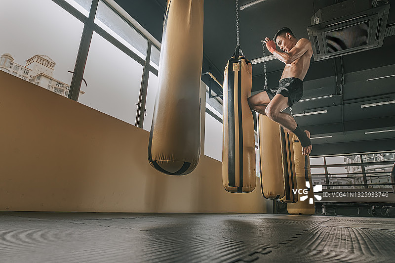 在健身俱乐部练习泰拳飞踢的拳击手图片素材