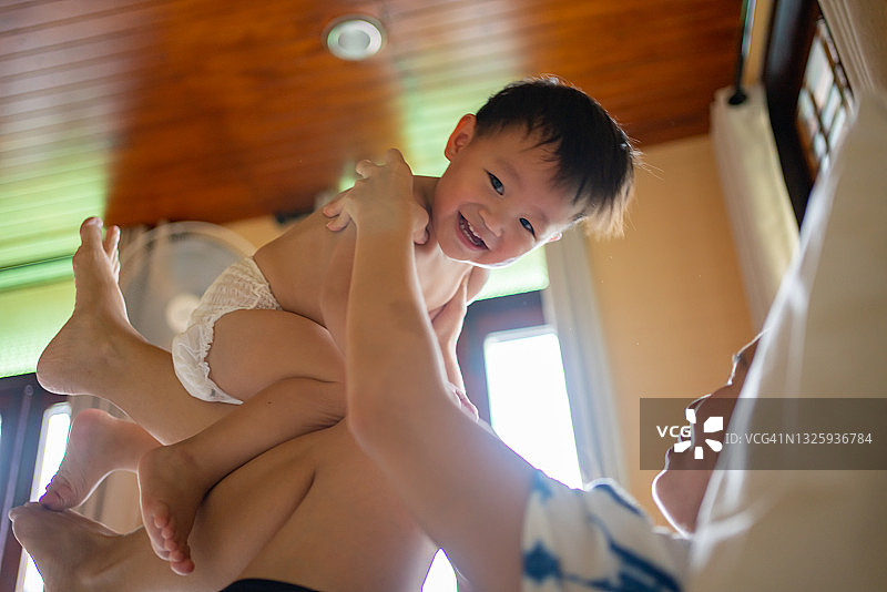 母亲和儿子在家玩假装飞翔图片素材