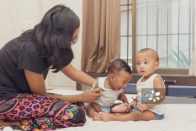 印度父母和他们的异卵双胞胎男孩玩耍图片素材
