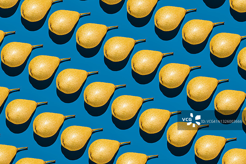 蓝色背景上重复排列的黄色梨图片素材