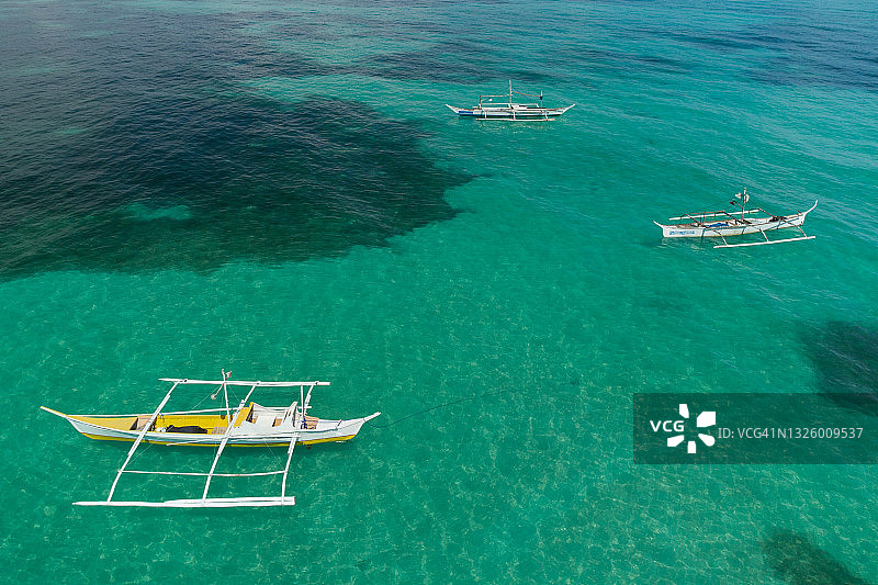 退潮时的三艘舷外支架独木舟图片素材