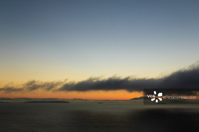 前景为朦胧云雾和剪影树木的壮丽日落图片素材