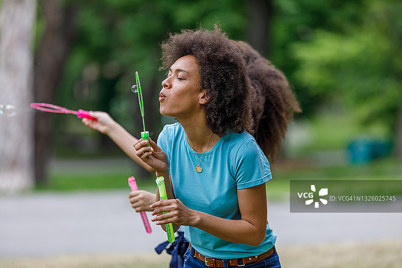 在公园里吹泡泡的非裔女性图片素材