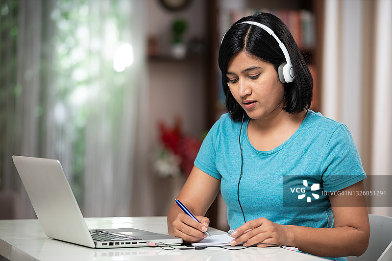 年轻女子在家中做电话销售和IT支持工作照片图片素材