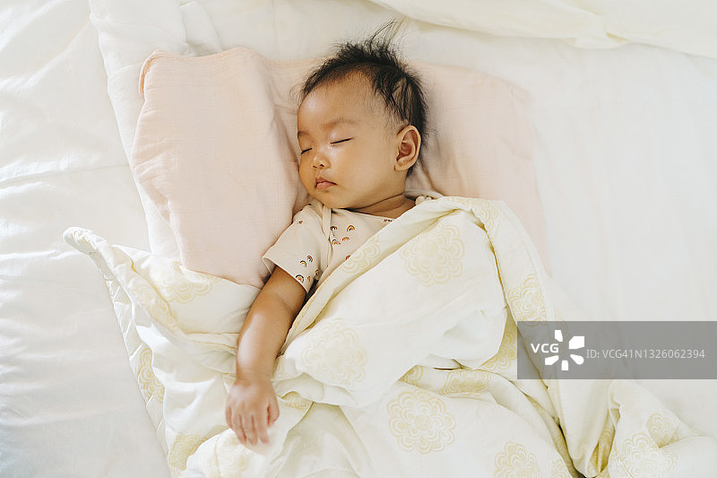 亚洲女婴在舒适的床上熟睡面部特写图片素材