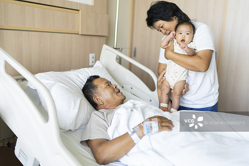 亚洲家庭祖母拥抱孙女，鼓励祖父早日康复的家庭生活场景图片素材