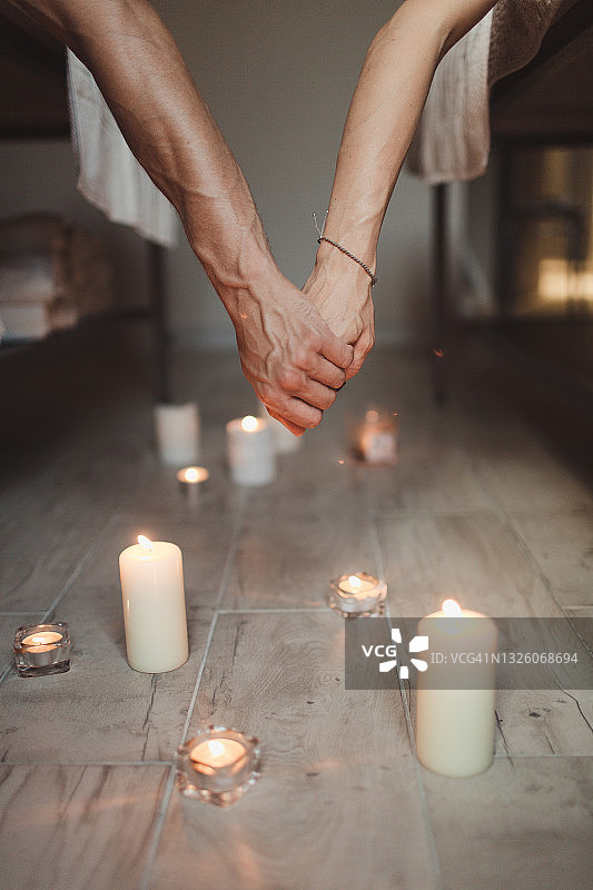 在水疗馆，一男一女享受联合按摩并手牵着手图片素材