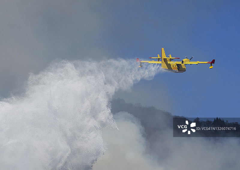 灭火飞机向森林火灾区洒水图片素材