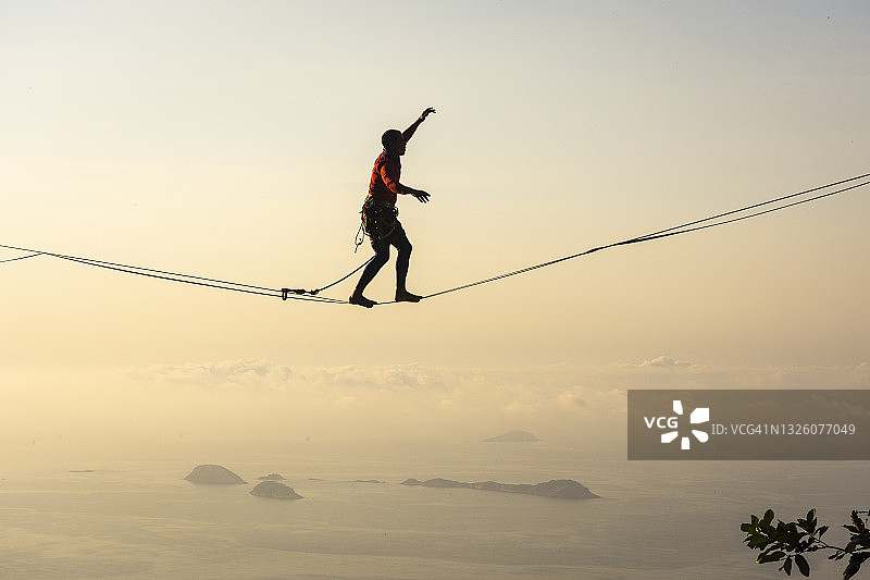 高空走绳者在山上海洋岛屿上的美丽景色图片素材