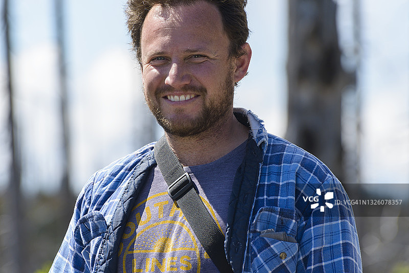 阳光下微笑的蓝法兰绒男子图片素材