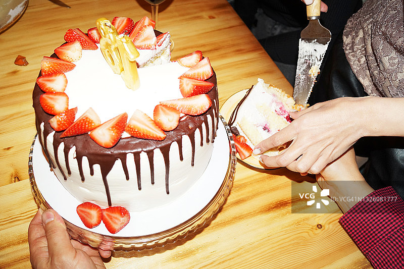 一位女士切生日蛋糕并分装到碟子里图片素材