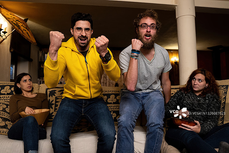 朋友们在乡间别墅里一边吃东西一边玩乐图片素材