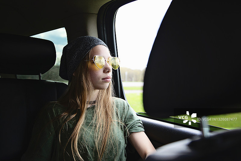 戴着太阳镜的金发少女坐在车里图片素材