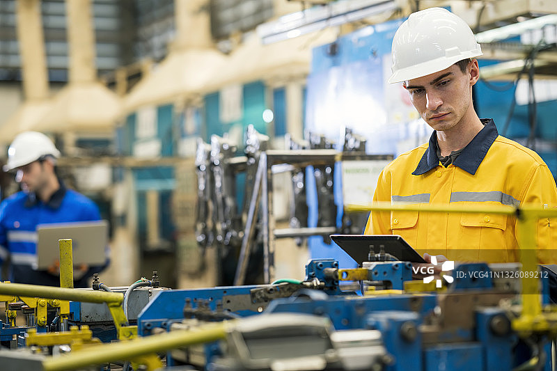 汽车工业中的焊接质量保证与质量控制流程。机械工程师正在生产线前检查底盘零件焊接装配夹具工具的精度。他们是质量控制方面的专家图片素材