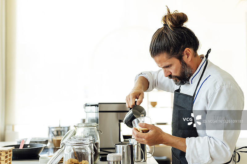 职业厨师在现代餐厅制作咖啡时倒入牛奶图片素材