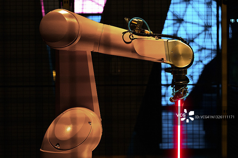 工厂中带有激光的照明机械臂图片素材