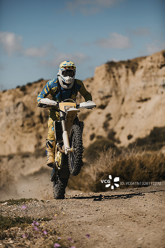 运动员在泥路上骑着耐力摩托车图片素材
