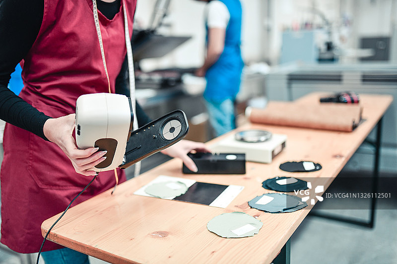 纺织厂里，女工更换机械分光光度计的镜头图片素材