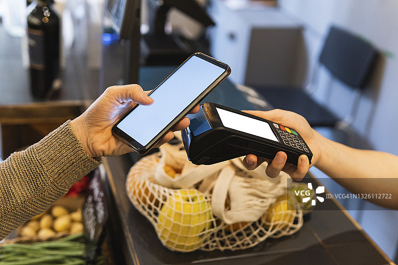 女顾客在超市用手机在线支付图片素材