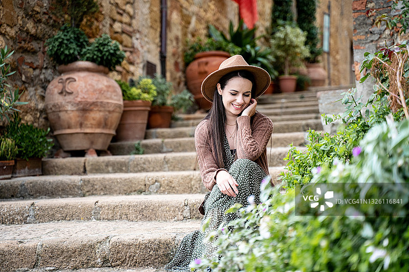 可爱的女孩坐在旧楼梯上图片素材