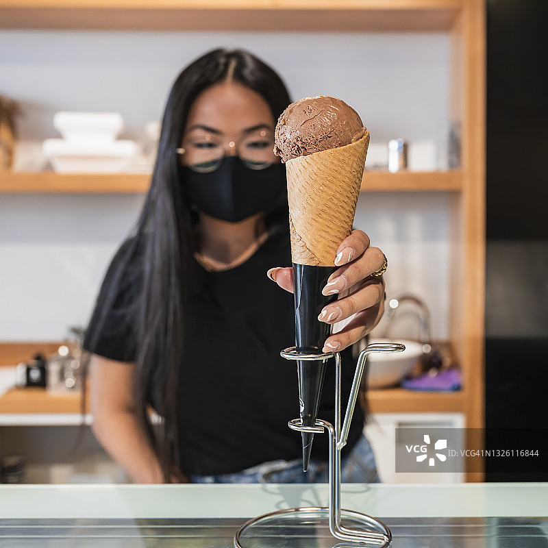 疫情期间，年轻女子在商店展示冰淇淋图片素材